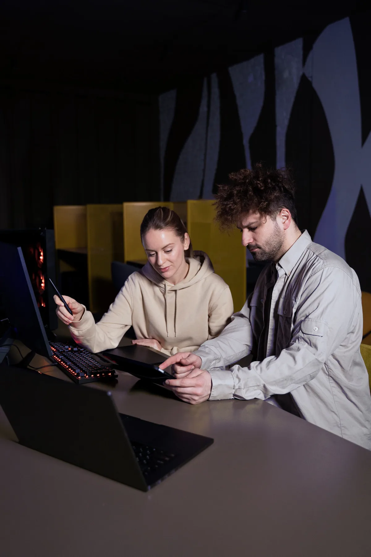 Two Acksession team members reviewing work together at a desk